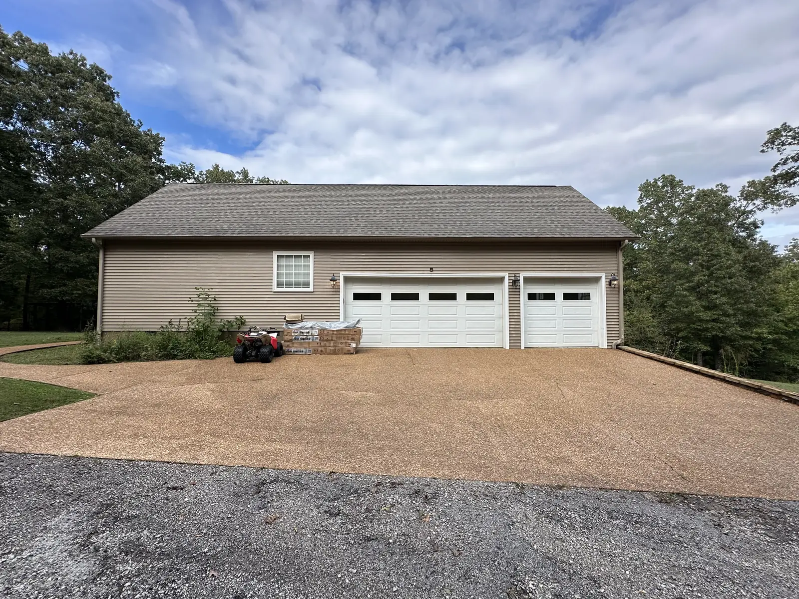 The same driveway from the same angle after power washing — bright, evenly cleaned concrete