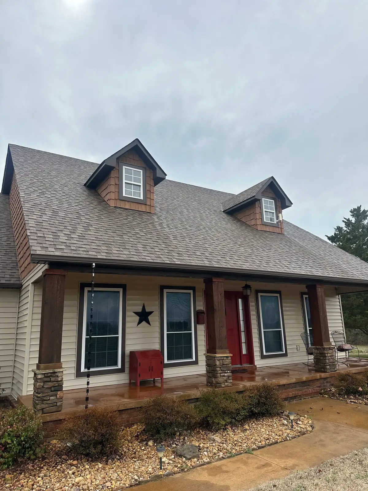 After soft washing: the same home's front elevation with clean siding, brightened roof shingles, and a freshly washed porch and concrete walkway