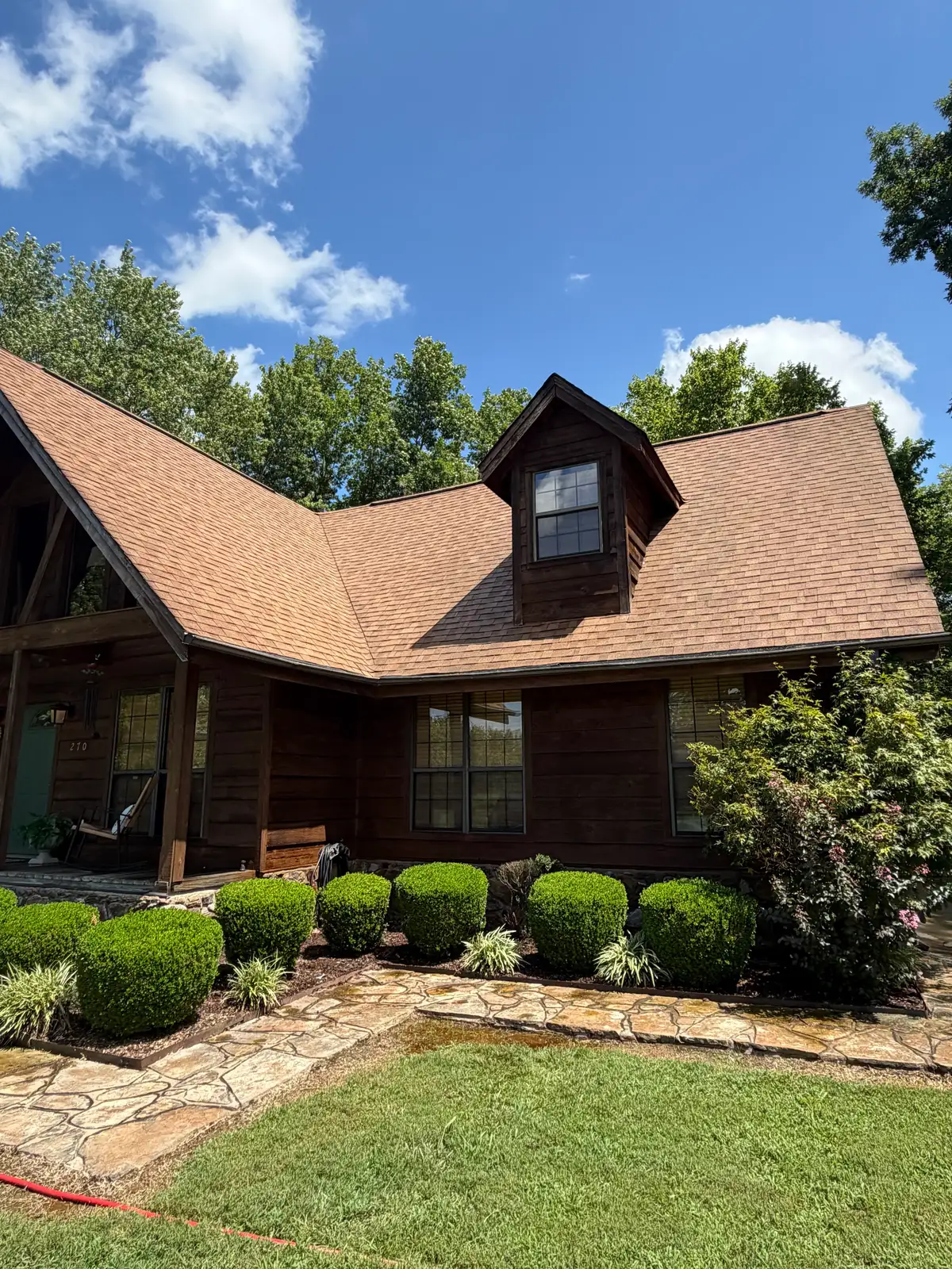 The same log cabin after roof washing — clean roof and refreshed logs
